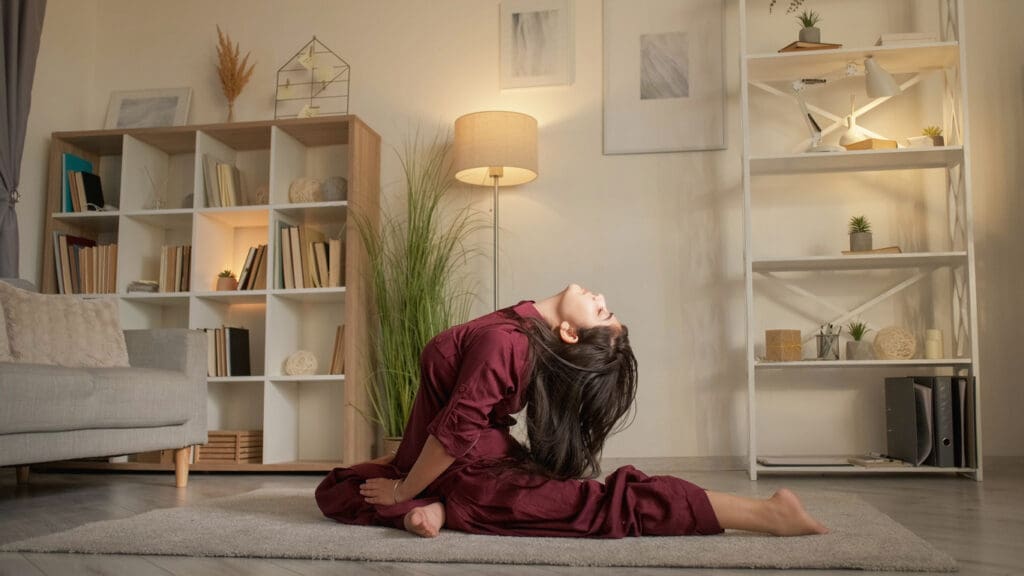 Yoga stretching. Flexibility exercise. Active hobby. Mindful woman practicing leg split workout pigeon pose back bend at home in living room.