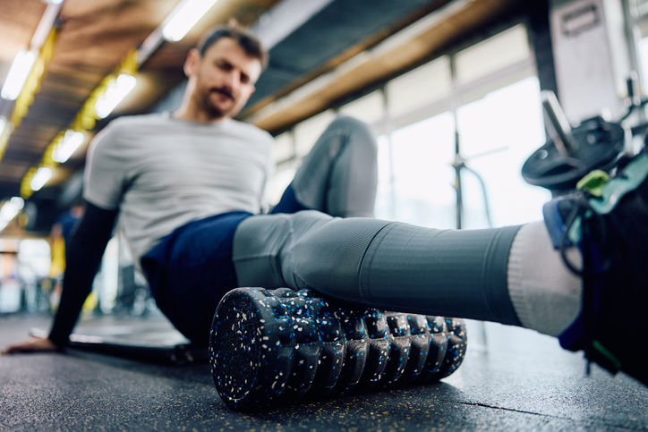 A man rolls out his fascia with a foam roller